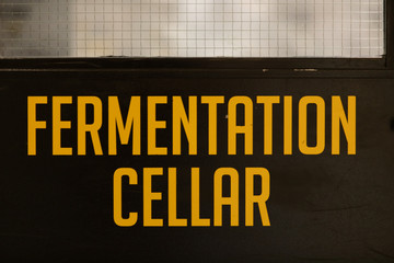 fermentation cellar yellow vinyl sticker text Information sign on a black door, industrial room symbol, selective focus and close up view