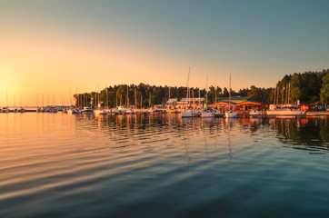 Boats docking in the marina at the Niegocin Lake during sunrise - Wilkasy, Masuria, Poland.