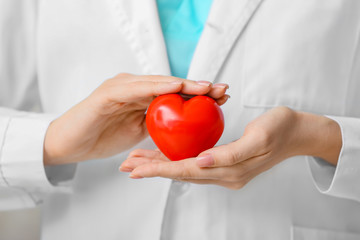 Female cardiologist with red heart, closeup