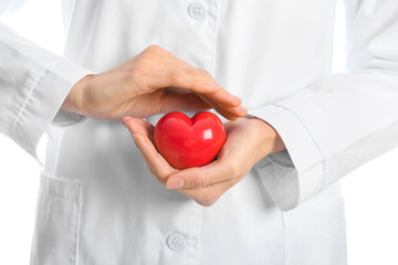 Female cardiologist with red heart on white background, closeup
