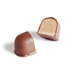 Chocolate candy with nougat broken into two halves. Sweet isolated with natural shadow on white, side view