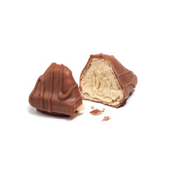 Candy decorated with chocolate glaze broken into two halves on white