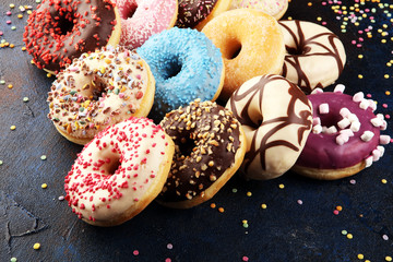 assorted donuts with chocolate frosted, pink glazed and sprinkles donuts