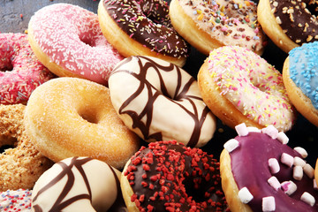 assorted donuts with chocolate frosted, pink glazed and sprinkles donuts