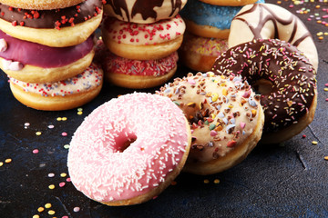 assorted donuts with chocolate frosted, pink glazed and sprinkles donuts