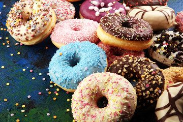 assorted donuts with chocolate frosted, pink glazed and sprinkles donuts