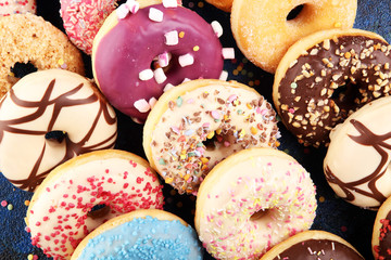assorted donuts with chocolate frosted, pink glazed and sprinkles donuts