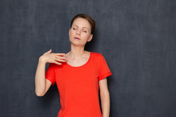 Portrait of overheated sweaty young woman waving hand to cool herself