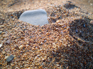 pebbles in the sand on the beach. sharpness in the center of the frame