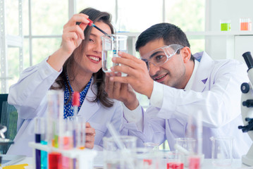 In a Modern Laboratory Research Scientist Conducts Experiments by Synthesising Compounds with use of Dropper and solution in a Test Tube.