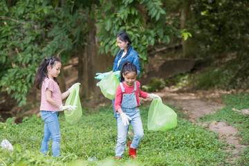 Fototapeta premium asian women and children volunteer help garbage collection charity environment river area. Group of kids school volunteer. Everyone has to help preserve the ecology on earth. (Environment concept)
