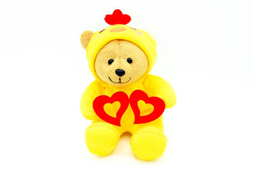 Valentine day concept. Yellow bear doll in chicken dress holding two red hearts isolate on white background. Cute object or toy and gift for special day.