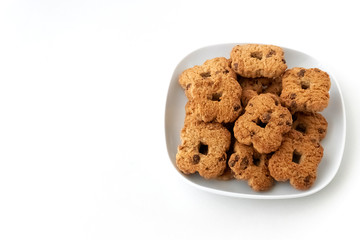 Chocolate chip cookies in ceramic white plate on white background.