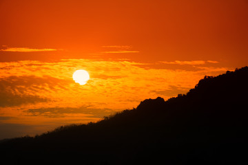 Fototapeta premium Beautiful sunset with dramatic sky.Tranquility view of sunset with silhouette mountain landscape background.