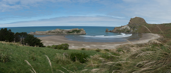 Panorama of a large, protected, sandy bay on the Wairarapa coast next to the Castlepoint Lighthouse in New Zealand.