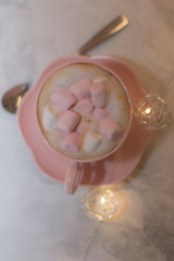 Chocolate caliente con bombones rosas en taza rosa