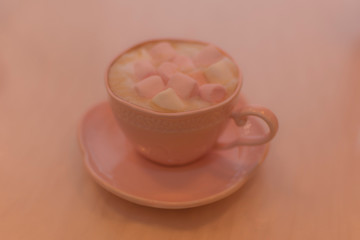 Chocolate caliente con bombones rosas en taza rosa