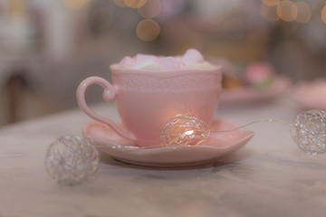 Chocolate caliente con bombones rosas en taza rosa