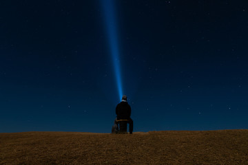 Night in the Mountain. Man Sitting Looking at the stars in the sky. Doi Samer Dao National Park (NAN Province, THAILAND)
