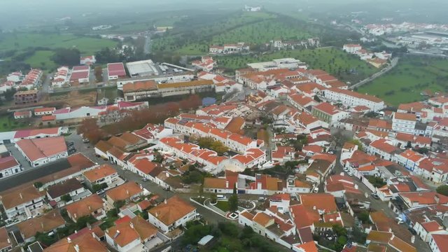 Aerial View Red Tiled Roofs of City Montemor-o-Novo, Portugal in a foggy day. Pan from left to right