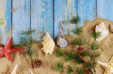 Christmas with holiday vacation on sand the background seashells and starfish on wooden board
