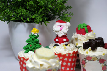 Christmas cupcakes decorated with Santa Claus with Christmas tree and gift and celebrate cupcakes.