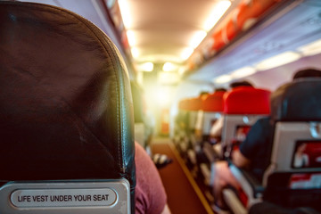 Interior of an airplane with passengers on seats waiting for takeoff.