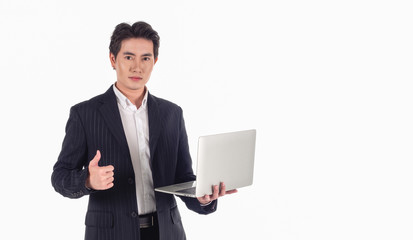 Portrait of Asian handsome businessman wearing a black suit, smiling at the camera with a gray laptop in his hand on a white background and copy space