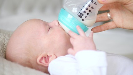 Mother Feeding Her Baby boy with A Bottle.