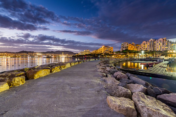 Fototapeta na wymiar Night panoramic view from public walking pier on central beach and promenade of Eilat - famous tourist resort and recreational city in Israel