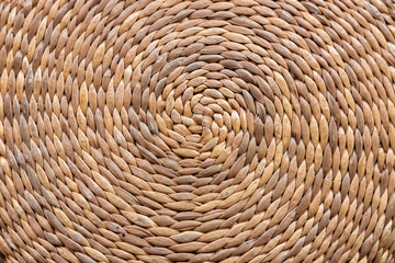 Straw out of bamboo knitted together in a circular pattern. Background.