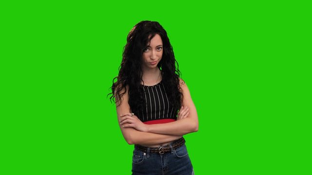 Beautiful Caucasian girl with long curly dark hair posing on green screen