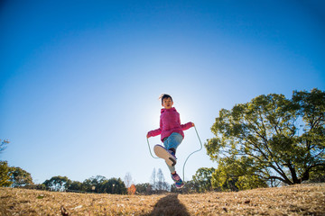 冬の公園で縄跳びをしている可愛い子供