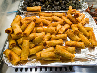 Pile of deep-fried spring rolls on food tray at hypermarket