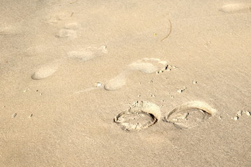 Fototapeta na wymiar Footprints of man and horse on the sand. Hoofprints of the animal and the person next