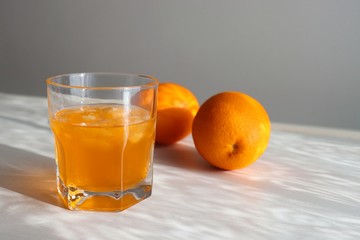 Orange fresh drink, glass of orange juice and ripe citrus fruits on white background