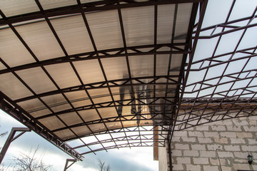 A worker mounts a metal canopy in the courtyard of the house