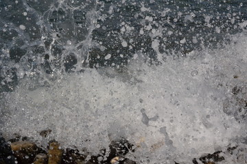 the sea coast in the afternoon with waves and splashes, the sea coast with stones.