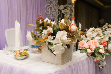 Composition of artificial flowers on the wedding table, Banquet table decor in a restaurant