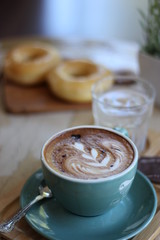 coffee in the morning, cup of cappuccino on wood table in cafe or coffeeshop.