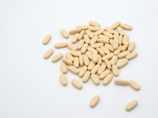 Light colored tablets are scattered on a white background. Selective focus