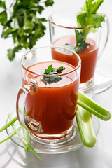 Tomato juice in a glass mug with celery stalks