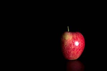 Ripe red apple on black background