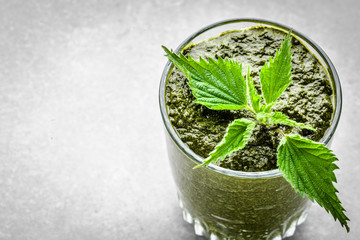 Glass of smoothie or green juice, detox drink with nettle leaves