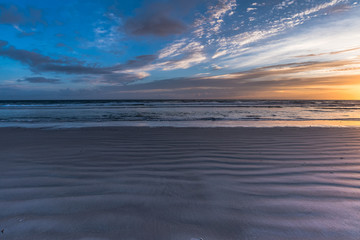 the wavy pattern of the sand at the beach