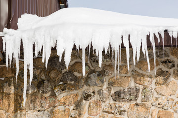 ice icicles on the eave of a roof