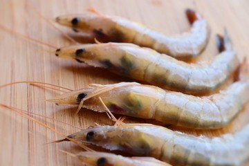 Fresh raw tiger prawns and spices on wooden Background