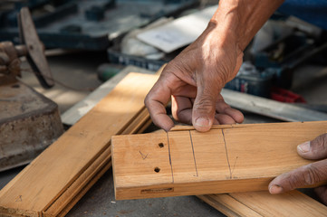 Carpenter working on a wooden plank at construction site