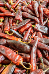 Dried chilis in a pile read for sale.