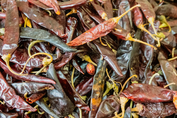 Dried chilis in a pile read for sale.